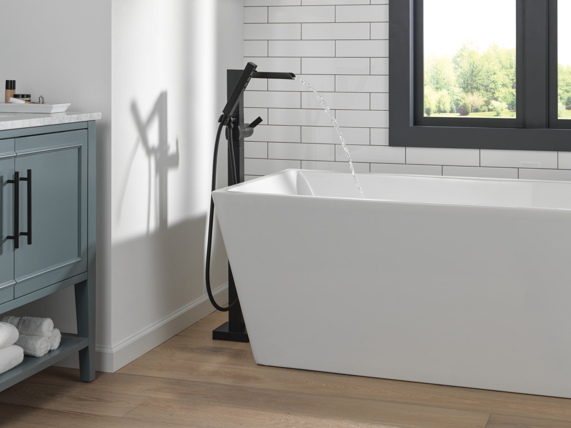 Delta Ara® Single Handle Floor Mount Channel Spout Tub Filler Trim with Hand Shower